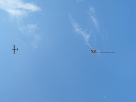 [picture: a plane flies overhead with a banner]